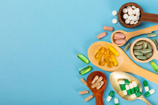 istock Vitamins and supplements. Variety of vitamin tablets on a textured background. Multivitamins with fresh and healthy fruits. Nutritional supplements. Flat layout. Place for text. Copy space 1906692799