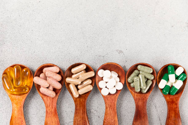 istock Vitamins and supplements. Variety of vitamin tablets on a textured background. Multivitamins with fresh and healthy fruits. Nutritional supplements. Flat layout. Place for text. Copy space 1906693325