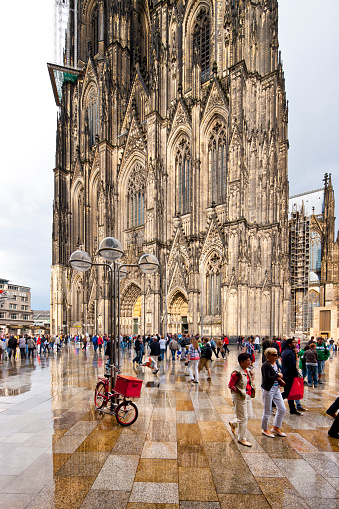 Cologne, Germany - 27. August 2011. Cologne Cathedral after a rain shower. View of the majestic west portal with the two towers. The square around the Cathedral, also known as the Domplatte, is extremely popular with tourists. Picture taken with 17mm tilt and shift lenses.