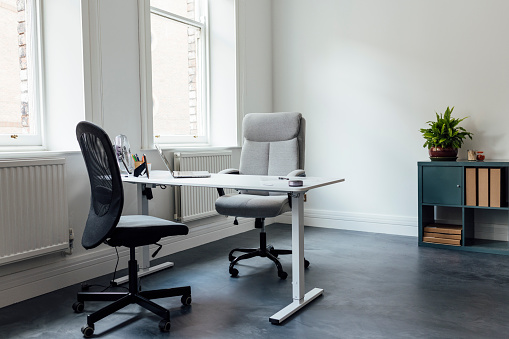 Wide view of an empty work office in Newcastle, England. In the room is a desk, office chairs and office equipment.