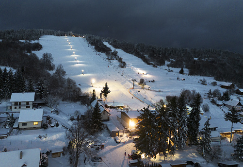 Winter ski slope at night with cable car
