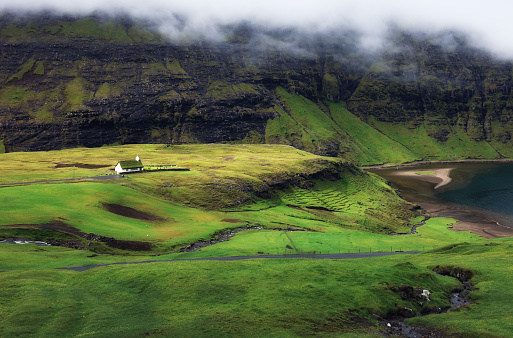 Green mountain landscape with old houses in Faroe islands, Saksun