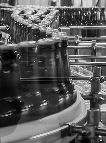 A close-up view of an assembly line with a series of bottles moving along a conveyor belt