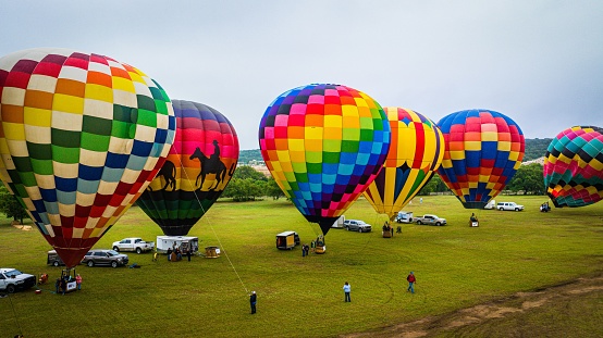 Horseshoe Bay, United States – April 08, 2023: A colorful display of balloons in various shapes and sizes, with a group of people gathered in the foreground