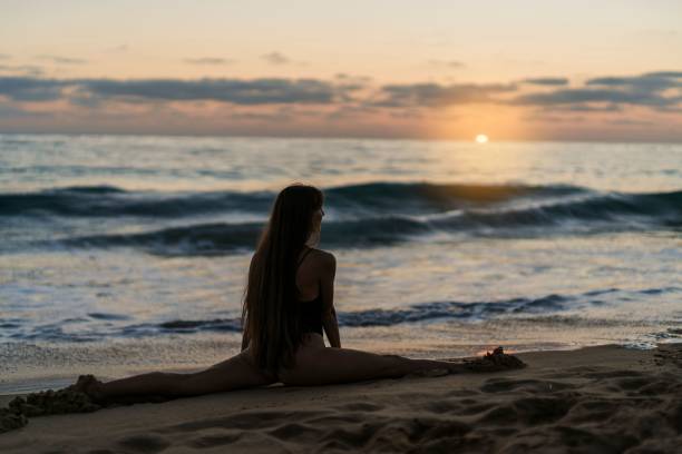 istock Young woman posing on a sandy beach at sunset 1906765163