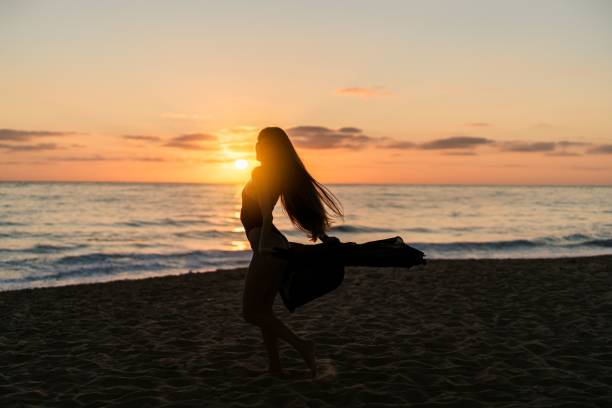 istock Young woman posing on a sandy beach at sunset 1906765166