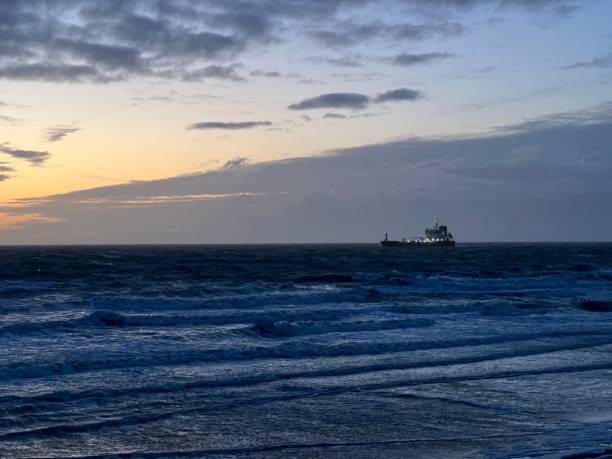 istock Vast blue ocean with a ship in the distance at sunset 1906767963