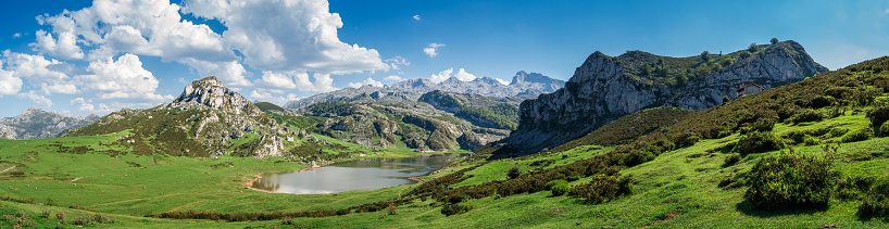 A scenic view of Covadonga Lakes in Asturias, Spain against a cloudy blue sky