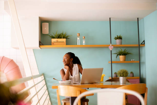 istock Young black woman having a healthy breakfast while working on laptop in the cafe 1906779911