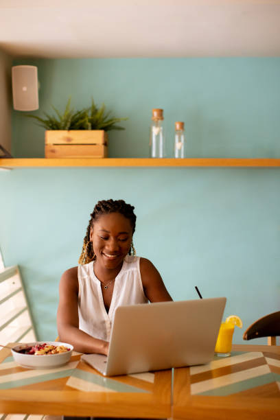 istock Young black woman having a healthy breakfast while working on laptop in the cafe 1906779913
