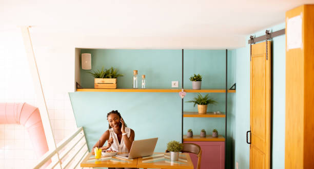 istock Young black woman drinking coffee  while working on laptop in the cafe 1906779927