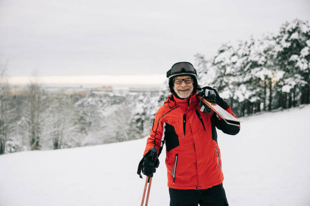 istock Portrait of active senior man with skis on shoulder 1906790925