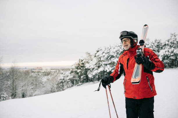 istock Active senior man walks with skis on his shoulder 1906791473