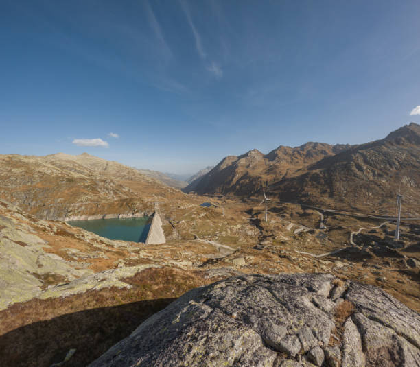 istock Dam and wind turbines on a mountain pass 1906799610