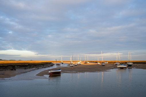 Low winter sun illuminates the marshes at low tide with pleasure craft