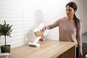 Woman vacuuming crumbs on table
