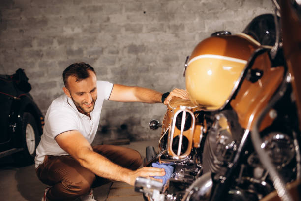 istock A man dusts off his retro motorcycle in the garage 1906838018
