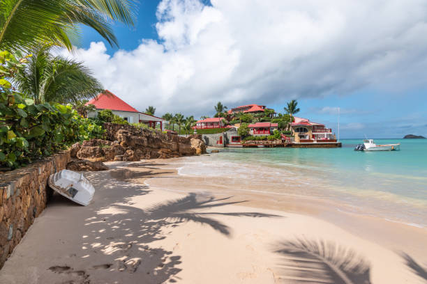 View of luxury beach on St Barts. Nikki Beach, Gustavia, Caribbean. Beach landscape with boat turned upside down against a wall on the beautiful luxurious white sandy beach of Nikki Beach on St Barts, Saint Barth or Saint Barthelemy, Windward Islands of the Lesser Antilles, Caribbean. st jean saint barthelemy stock pictures, royalty-free photos & images