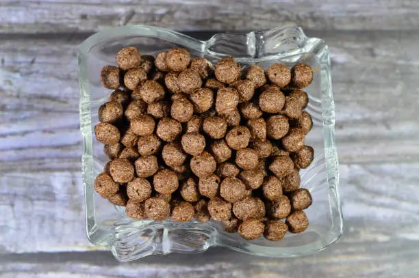 Photo of Breakfast Chocolate flavored balls cereal, as a snack prepared with milk for children and adults, crispy crunchy chocolate flavored balls