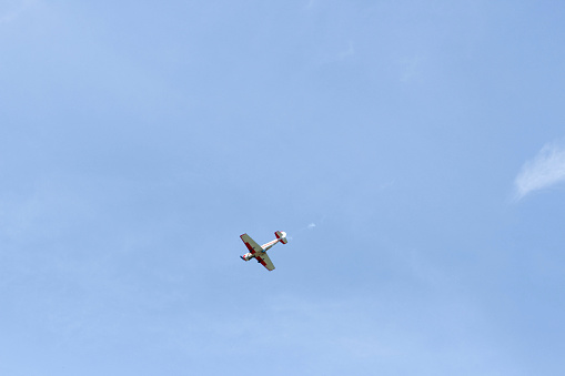 A small plane in the sky with space for text. Single plane flies lonely in the clear blue sky. Single propeller aircraft flying in heaven.
