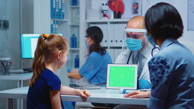 Doctor holding green screen tablet