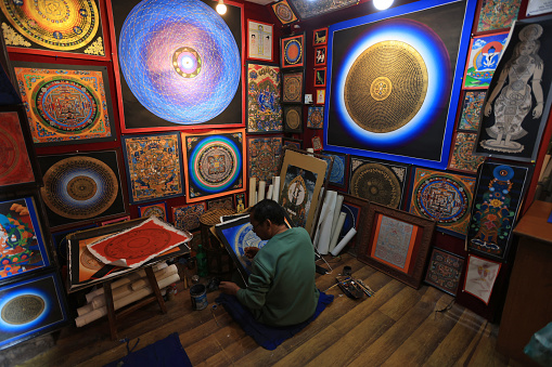 Kathmandu, Nepal - November 25 2023: artist work in Thangka stores is opened in Bhaktapur Durbar square. Thangka is a tradiitional tibetan buddhist painting, usually depicting a buddhist deity