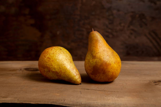 istock Two pears on wooden background. 1906888107