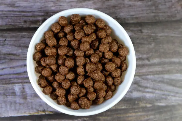 Photo of Breakfast Chocolate flavored balls cereal, as a snack prepared with milk for children and adults, crispy crunchy chocolate flavored balls