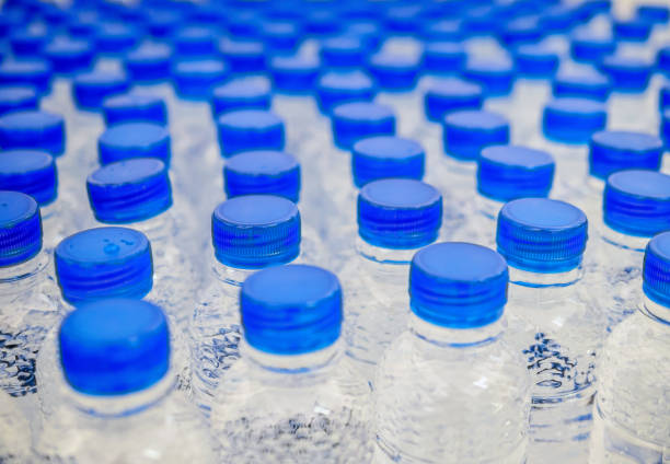istock Many blue drinking water bottle caps and pure drinking water bottles in a drinking water production plant. 1906897049