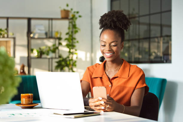istock Beautiful woman sitting in an office and using phone 1906902939