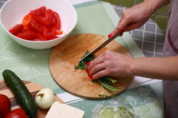 istock Woman cutting fresh arugula in kitchen 1906904393