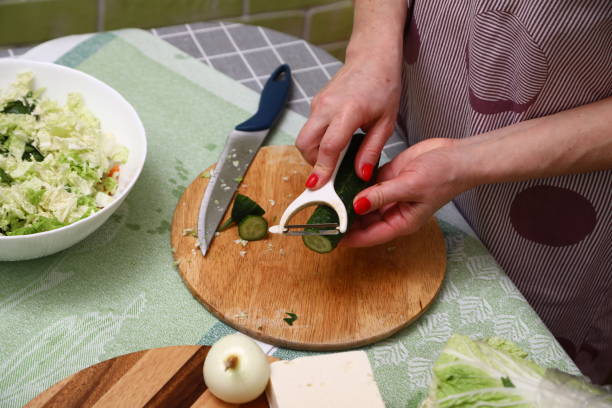 istock Female peeling cucumber in a home kitchen 1906910256