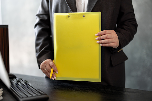 Young beautiful businesswoman holding colorful documents outdoors