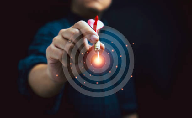 Businessman throwing red dart to virtual dartboard for achievement business objective target and goal concept.