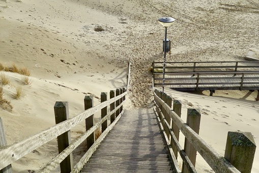 Wooden boardwalk over sand dunes at the coast of island Sylt, German North Sea Region