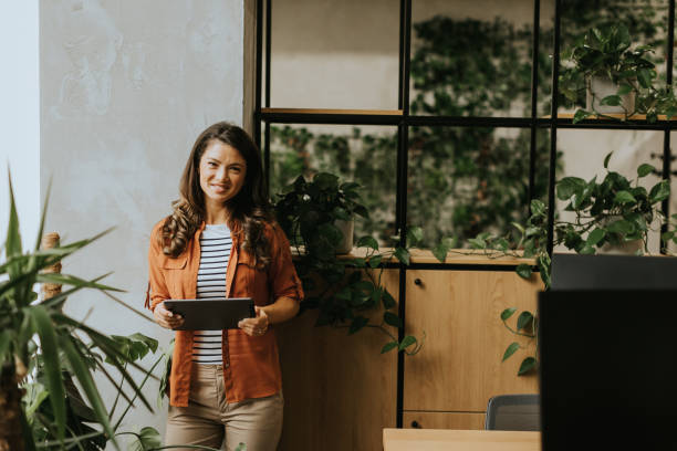 istock Young woman standing with digital tablet at the office 1906989677