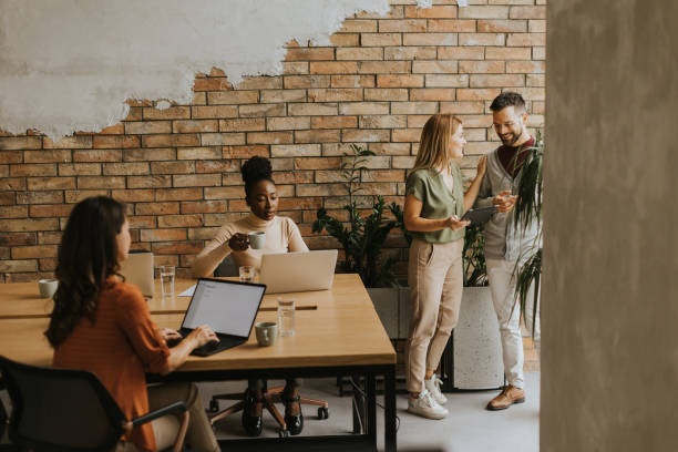 istock Young multiethnic startup team working by the brick wall in the industrial style office 1906989715