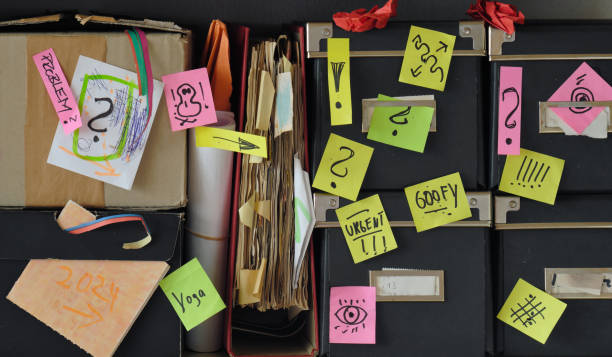 istock messy shelf with file folder,sticky notes,old papers and storage boxes.Red tape, bureaucracy,aministration,messy office and chaotic business concept. 1907001104