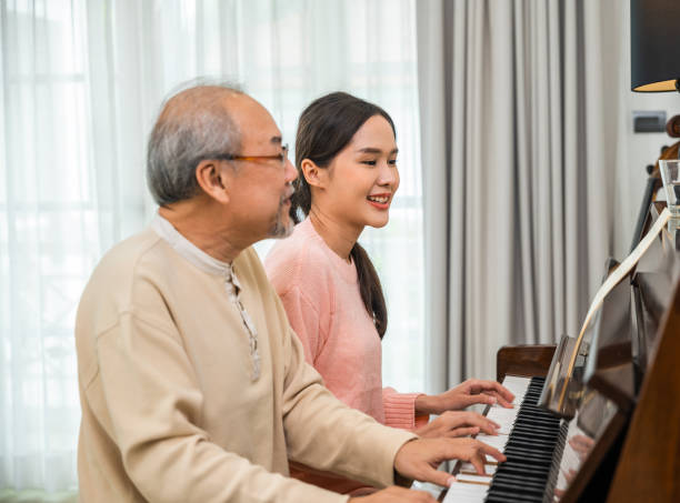 istock Asian young woman teaching piano for senior man teaching 1907003318