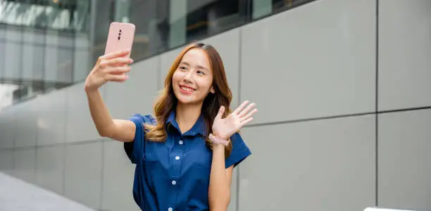 Photo of Trendy young woman capturing a selfie with her smartphone in the city