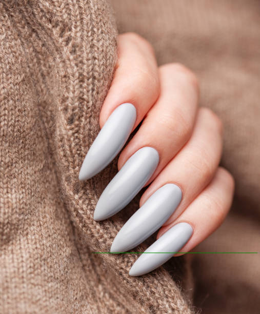 istock Woman's hand with grey nail polish 1907007814