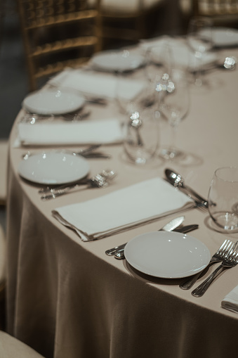 A formal dining table set up with white plates and silverware