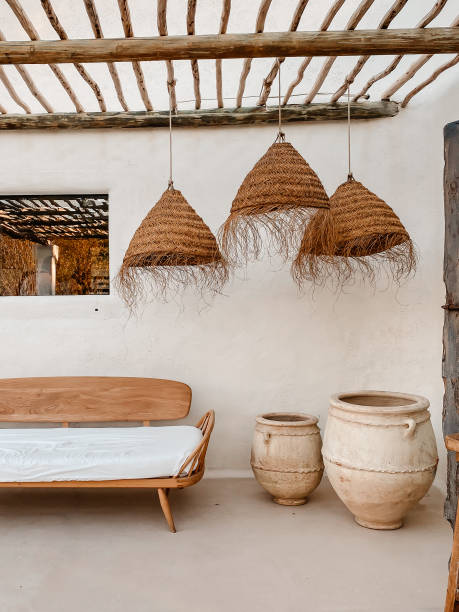istock Cozy rustic interior with a bench, clay vessels and rattan lamps 1907018316