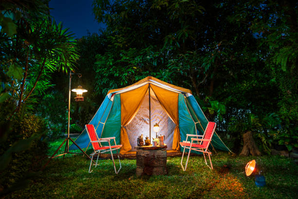 vintage cabin tent,  antique oil lamp, retro chairs, group of camping tents with outdoor coffee-making facilities on wooden tables in a forest camping area in the forest. - lantern lamp hurricane old 뉴스 사진 이미지