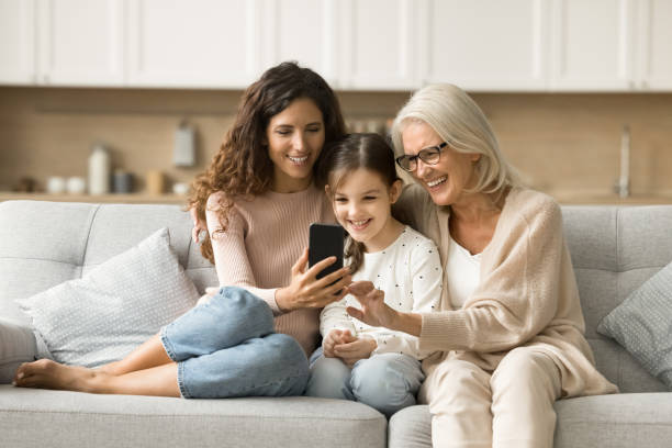 istock Cheerful mother, grandma and kid using digital gadget 1907023825