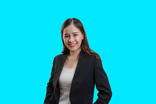Asian Young Businesswoman on isolated blue background, Beautiful Woman Looking At Camera, Woman Positive Emotion, Success and Pride.