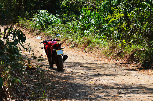 Thai man biker biking motorcycle or travelers people riding motorbike travel visit Ban Taphoen Khi Karen Village top of Khao Thewada Angel Mountain at Phu Toei National Park in Suphan Buri, Thailand