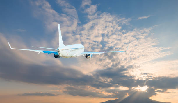 istock Airplane flying over tropical sea at sunset 1907071429