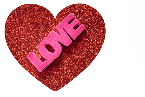 LOVE on top of a red glitter heart on white background.