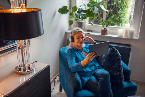 istock Beautiful blonde woman using streaming devices at home 1907098805